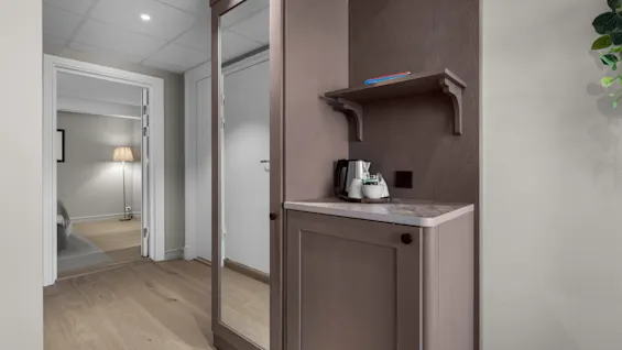 An inviting hotel room hallway with a refreshment station and a view into the adjoining sleeping area.