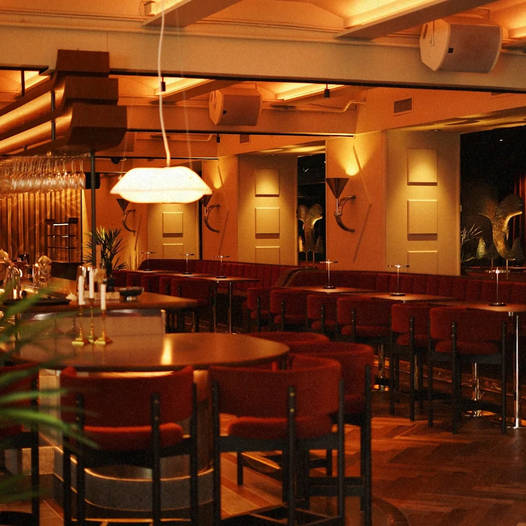 En varm och inbjudande bar på Clarion Hotel Post, med bekväma sittplatser och stämningsfull belysning.