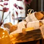 En rustikk trekasse fylt med et utvalg ferskt brød, delvis innpakket i rutete tøy, på et buffetbord.