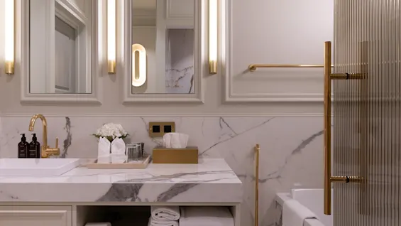 Elegant marble bathroom with a double mirror vanity, warm lighting, and a modern bathtub.
