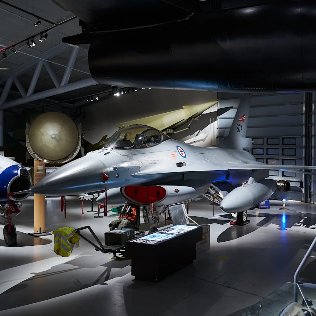 Militära stridsflygplan utställda i en stor och mörk flygmuseumhall