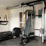 Et moderne fitnessrum med en elliptisk træner og en alsidig vægtmaskine med en bænk, der indbyder til en god træning.