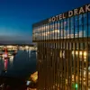 The facade of Clarion Hotel Draken at night with the sea in the background.