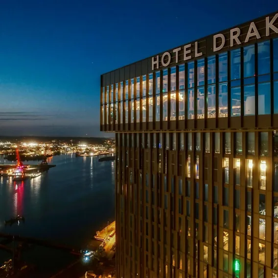 Fasad på Clarion Hotel Draken på natten, med havet i bakgrunden.