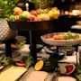 En livlig buffé med frisk frukt, grønnsaker, pålegg og oster på serveringsfat i flere nivåer.