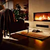 Cosy armchair with a blanket draped over it faces a lit fireplace. Slippers on a rug complete the warm, inviting setting with plants and soft lighting.
