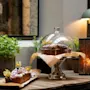 Delicious cakes and pastries displayed on a wooden table with green plants and warm lighting at Home Hotel Grand Bodø.