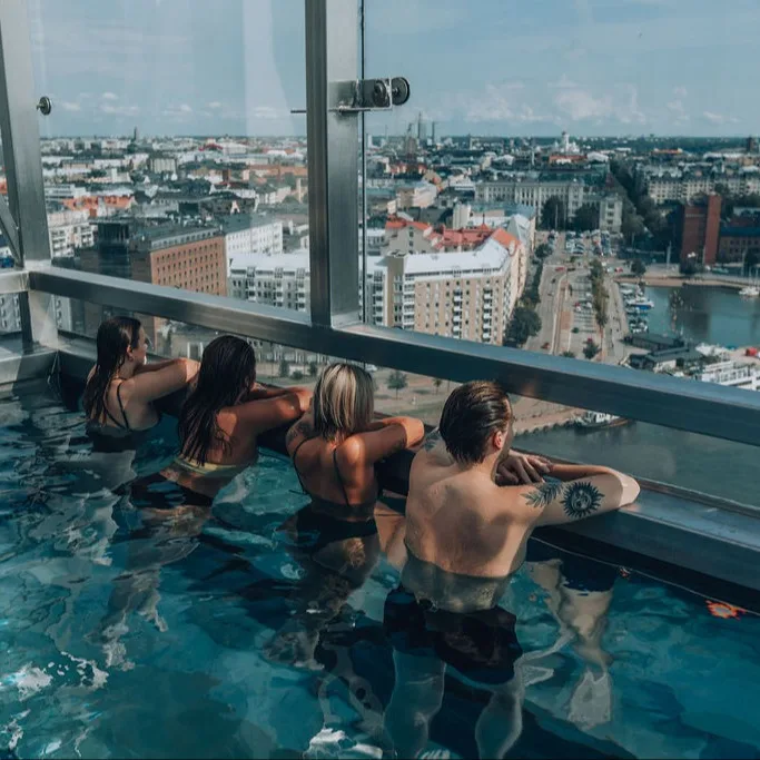People enjoying the view from a rooftop pool in Helsinki.