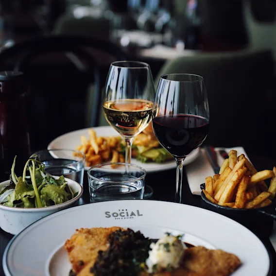 En utsökt måltid på The Social Bar and Bistro, med schnitzel, pommes frites, sallad och vin på Quality Hotel Arlanda XPO.
