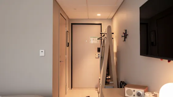 Hyvin varusteltu hotellihuoneen sisäänkäynti, joka tarjoaa mukavuuksia, kuten naulakon, television ja radion vieraiden viihtyvyydeksi.