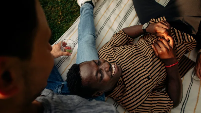 A guy lying in the grass laughing.