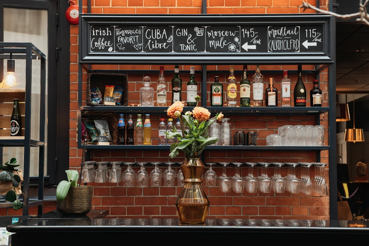 Et barområde med en menytavle som viser drikkealternativer som Irish Coffee, Cuba Libre, Gin og Tonic, Moscow Mule og Mocktail.