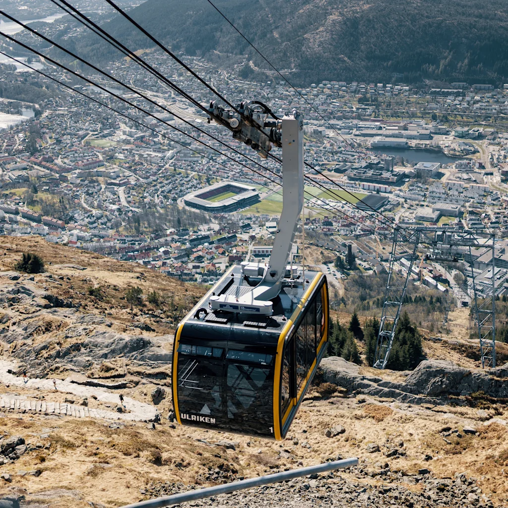 Henkilö nauttimassa luonnonkauniista näkymistä Ulrikenilta Bergenissä, luonnon ja vuorten ympäröimänä.