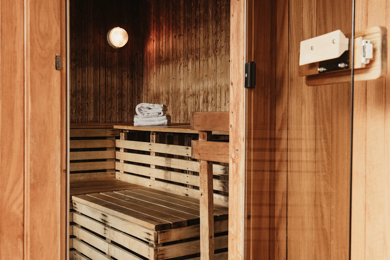 An inviting wooden sauna, ready for relaxation, with towels on a shelf.