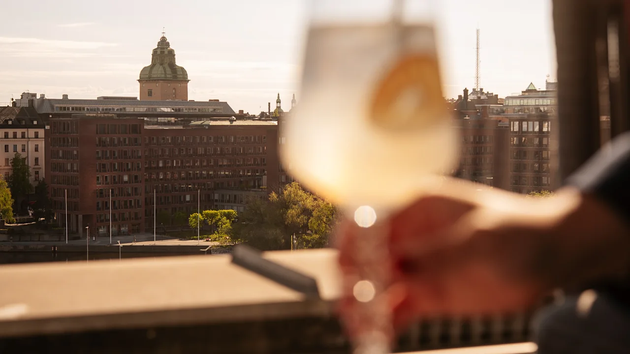 Nauttimassa virkistävästä juomasta kattoterassilla kaupunkinäkymällä Clarion Hotel Signissa.