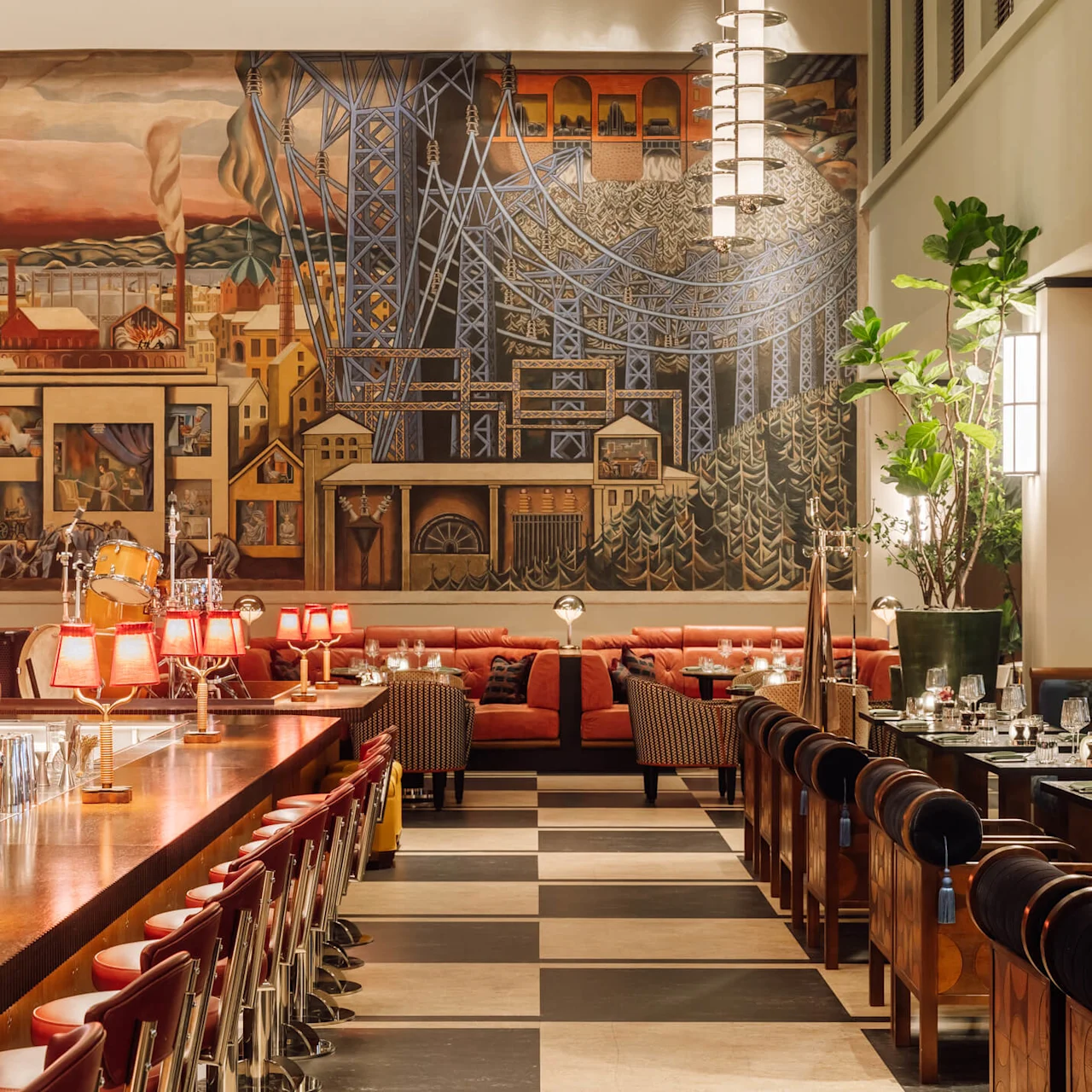 Et elegant interiør med et stort vægmaleri, art deco-belysning og luksuriøse siddepladser i et rum med højt til loftet.