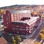 Luftfoto af en efterårsby med en stor rød bygning mærket HOTEL SUNDSVALL og FOLKETS HUS, omgivet af gule træer.