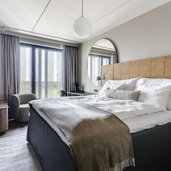 Superior-huone Clarion Hotel Helsinki Airportissa. Moderni ja kutsuva hotellihuone mukavalla sängyllä, työpöydällä ja suurilla ikkunoilla.