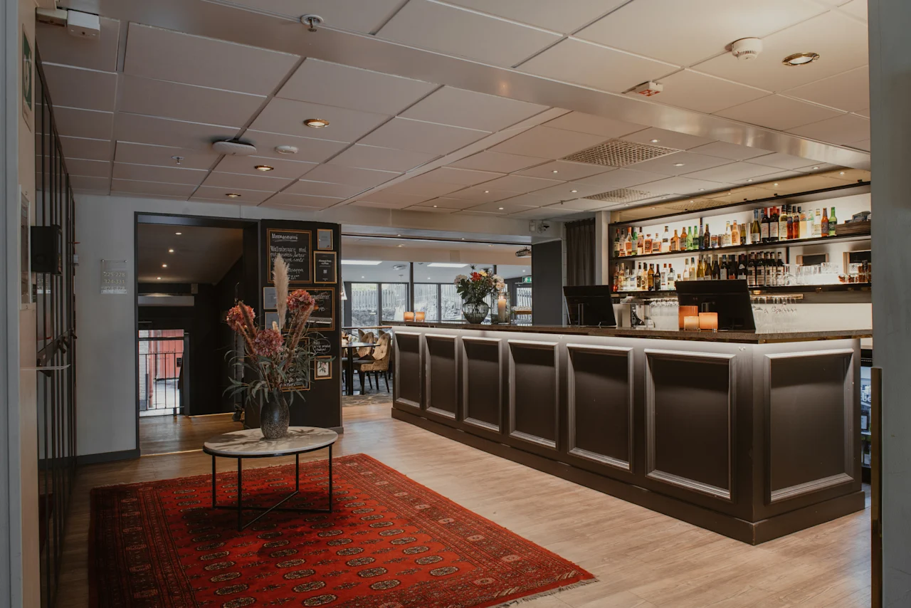 Home Hotel Kung Oscar: A welcoming hotel bar and lounge, featuring a fully stocked bar and a cozy atmosphere for guests to relax.