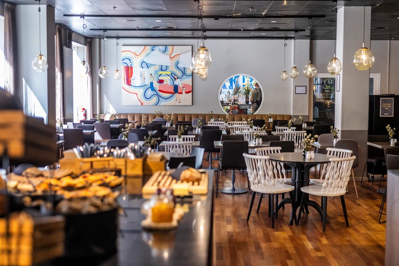 A bright and modern dining area at Comfort Hotel Vesterbro with a buffet in the foreground and many tables set for guests. DONT FORGET YOUR KEYCARD