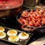 A delicious breakfast spread at Home Hotel Grand Bodø featuring crispy bacon, perfectly cooked eggs with chives, and a warm pot.
