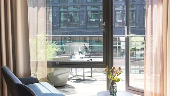 A hotel room at Farris bad in Larvik with a balcony view, featuring outdoor seating and a chilled bottle, ready for relaxation.