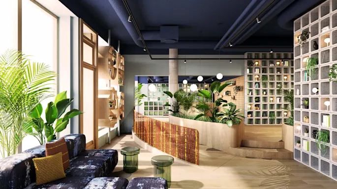 A stylish lounge features vibrant plants in decorative planters, surrounded by modern shelving with books and decorations. Soft seating and glass tables create a cozy, contemporary atmosphere.