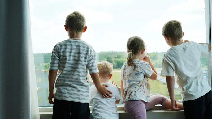 Children looking out a window at Quality Hotel Arlanda XPO, enjoying the view together.