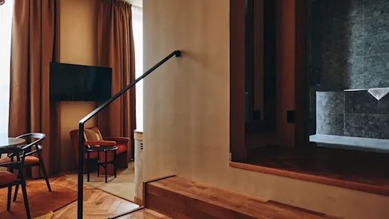 The Dock: Et moderne interiør med tretrapper som fører til et oppholdsrom og et bad, med varme farger og stilig innredning.