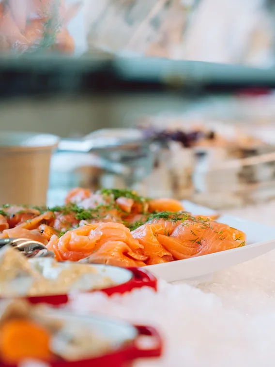 Raikas hotelliaamiaisbuffet jossa tarjolla lohta ja lisukkeita jäillä
