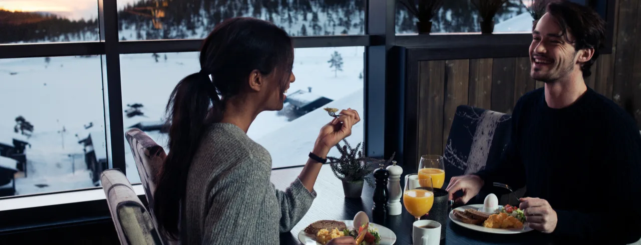 A couple eating lunch by the window at Matbaren at Norefjell Ski & Spa.