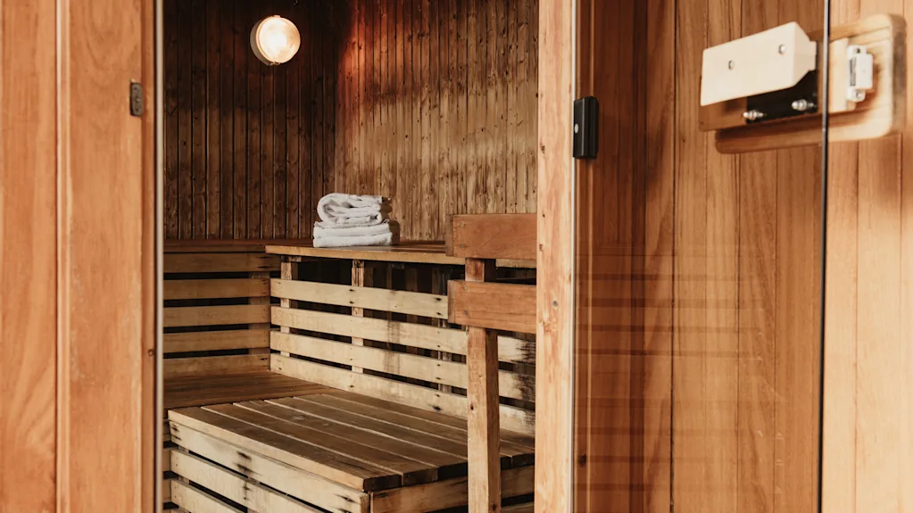 An inviting wooden sauna, ready for relaxation, with towels on a shelf.