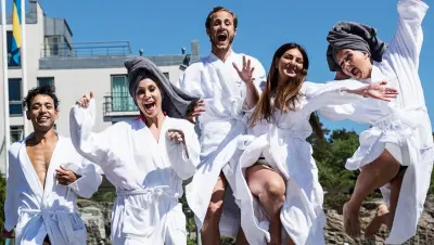 A group of friends dressed in white bathrobes on their way to the beach.