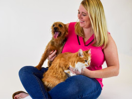 A woman holding a dog and a cat hoping to find the best pet insurance for her pets.