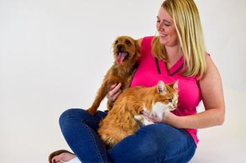 A woman holding a dog and a cat hoping to find the best pet insurance for her pets.