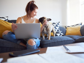 A woman on a couch with her dog in an apartment