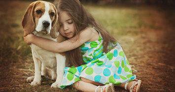 sad little girl hugging beagle