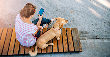 girl on the phone sitting with her dog