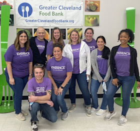 Embrace Pet Insurance Marketing Team presenting donation check at volunteer event