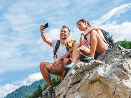 dog and people taking photo on rock ledge