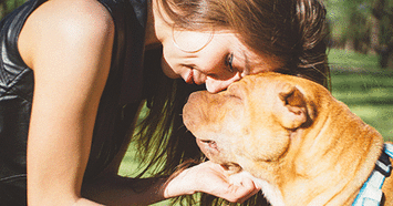 Woman touching heads with dog