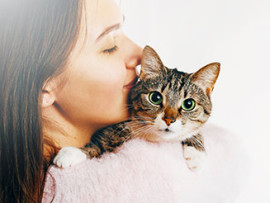 cat being held by a woman with dark hair