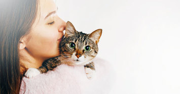 cat being held by a woman with dark hair