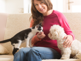 woman on couch with dog and cat