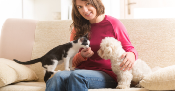 woman on couch with dog and cat