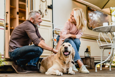 Dog and Older Couple Outside RV Camper