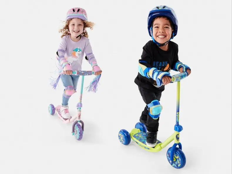 kids riding colourful scooters wearing matching helmets