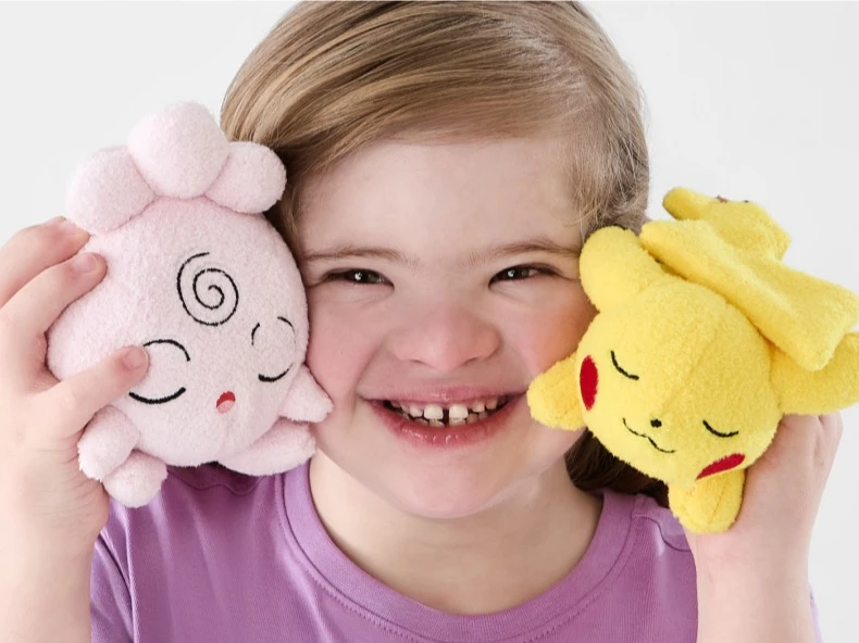 Young girl happily playing with plush toys