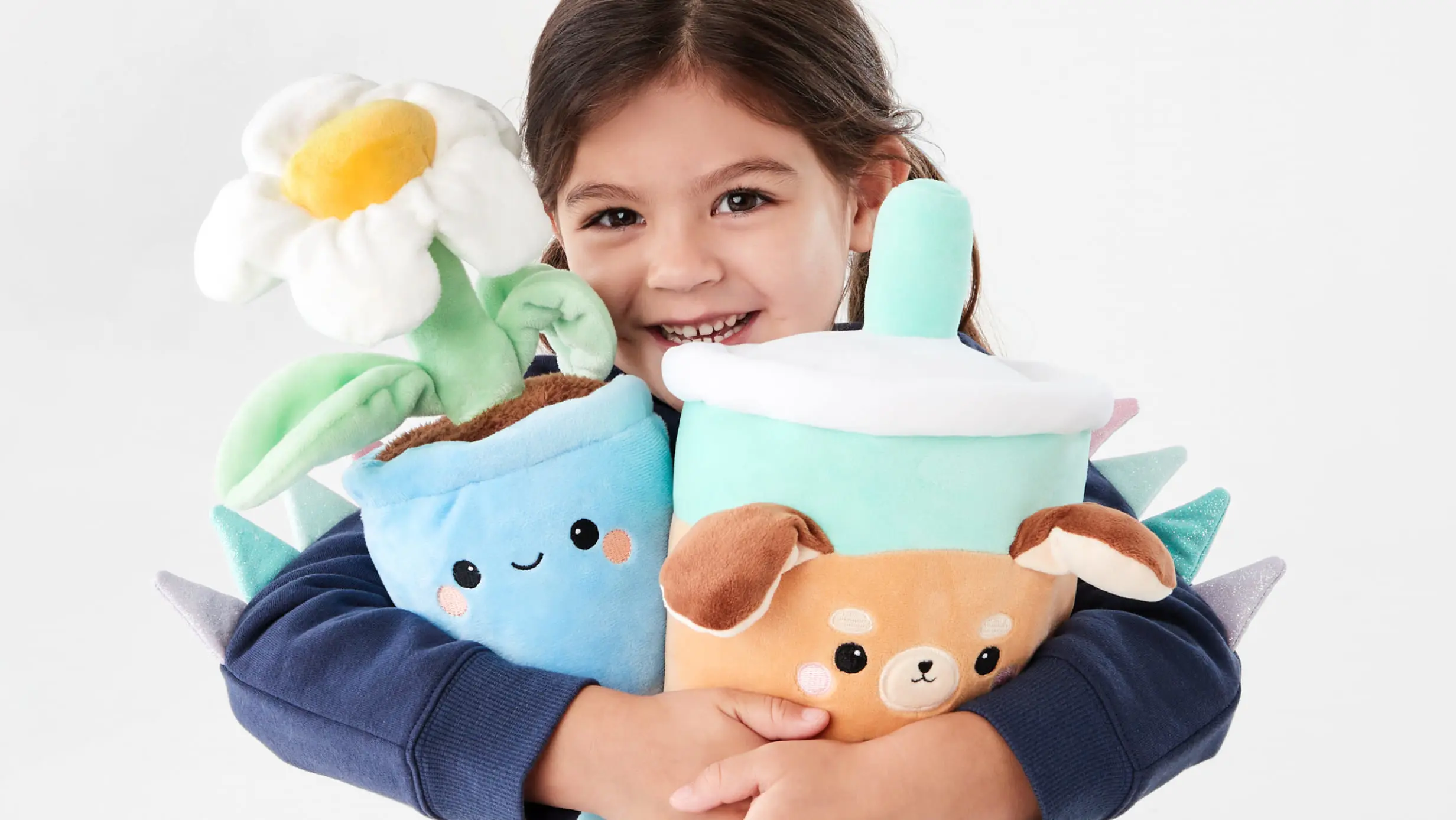 young girl holding an assortment of plush toys