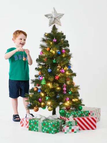 Little boy decorating the Christmas Tree with Christmas Baubles & Tree D